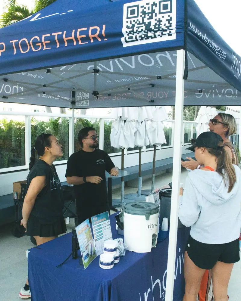 The Rhovive founders talking with visitors at the Get your sip together tent