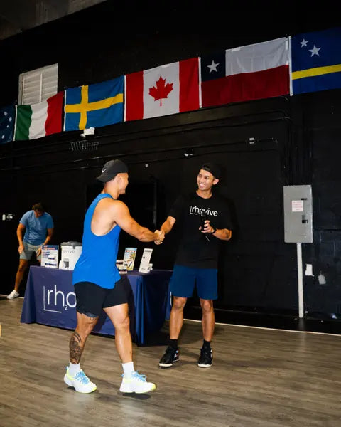 A Rhovive founder shaking hands with an athlete at an indoor event