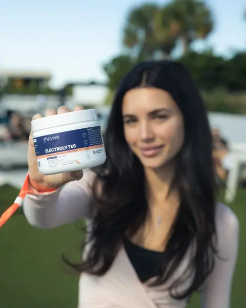 A woman holding up a jar of Rhovive Peach